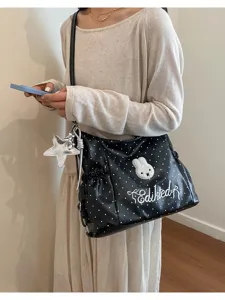 Borsa a tracolla a pois neri e bianchi vista dettaglio con ricamo di coniglio carino.