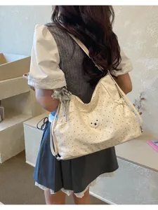 Vista di dettaglio della elegante borsa a tracolla a pois con morbido patch peluche e ricamo chic.