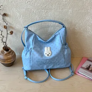 Vista dettagliata della borsa a pois blu con graziosa toppa di coniglio e ricamo.