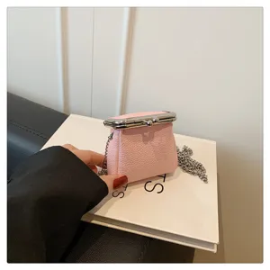 Mini pink kiss-lock coin purse with chain strap, stylish small lipstick bag for women.
