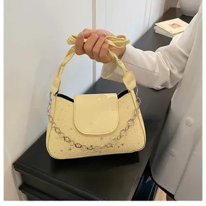 Vista dettagliata della borsa gialla alla moda con borchie a stella e catena decorativa.