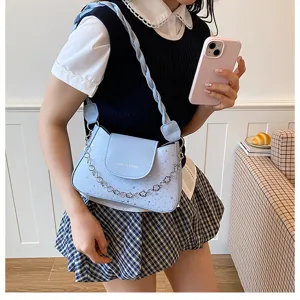 Vista dettagliata della borsa a tracolla azzurra elegante con catena e stampa a stelle.