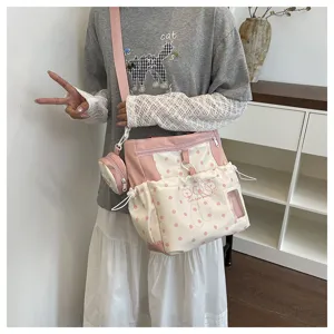 Chic women's pink polka dot shoulder crossbody bag with matching mini pouch for daily commute style.