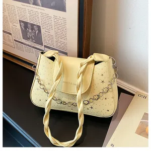 Borsa a tracolla gialla alla moda con manico intrecciato, motivo a stelle e catena.