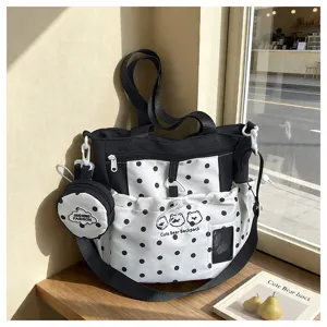 Detailed shot of black and white polka dot canvas crossbody bag with cute bear print and pouch.