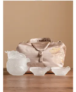 Set da tè drago in vetro satinato con una teiera, due tazze e una borsa di stoccaggio.
