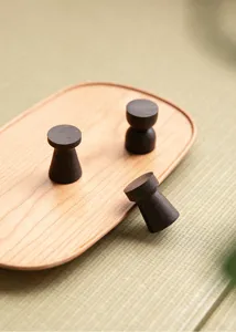 Dettaglio supporto per coperchio in legno scuro fatto a mano, accessorio tè.