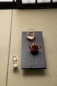 Japanese wabi-sabi charred wood tea tray set with teapot and cups for classic tea ceremony.