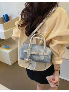 Stylish denim boston shoulder bag for women, trendy commuter crossbody bag with star charm.