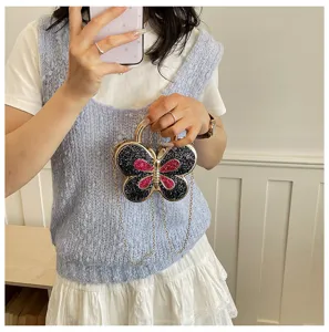 Detailed view of sparkling butterfly acrylic clutch bag with metal frame and chain strap.