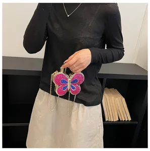 Detailed view of the sparkling butterfly evening bag with glitter and metallic chain strap.