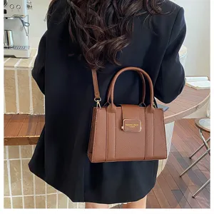 Sac bandoulière en cuir marron, élégant sac à main pour navetteur avec détail métallique.
