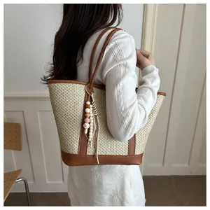 Dames zomer stro tote tas met bruine lederen afwerking en kralen hanger voor dagelijks.