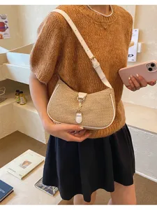 Straw woven shoulder bag detail, white leather trim and metal clasp, stylish underarm bag.