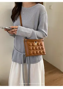 Elegante borsa a tracolla marrone con logo V dorato, bolle soffici e design retrò chic.