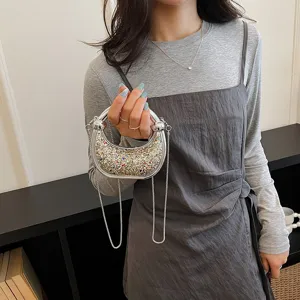 Mini rhinestone acrylic evening bag with metallic round handle and chic shoulder chain strap.
