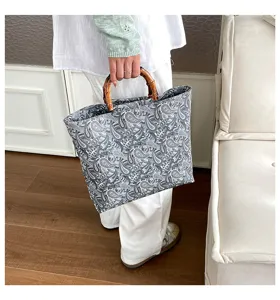 Vista detallada de bolsa floral de gran capacidad con asas de bambú para uso diario.