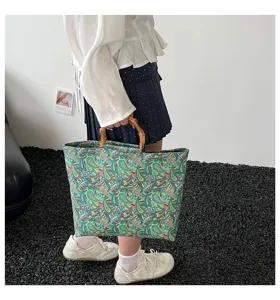 Bolso tote grande con estampado floral de estilo étnico y asa de bambú para uso diario.