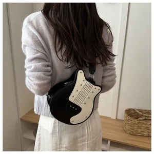 Guitar shaped crossbody bag detail, stylish black white colorblock with cool rivet accents.