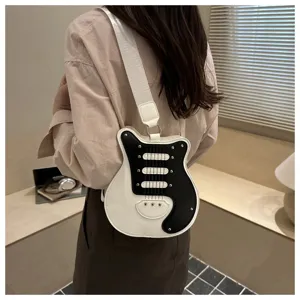 Unique guitar shape crossbody bag with black and white color block design and studs.