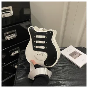 Guitar shaped crossbody bag detail showcasing black white color block and metal rivets.