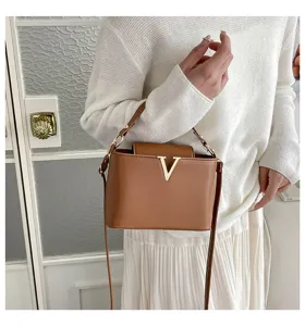 Vue détaillée du sac à bandoulière marron élégant avec logo V doré pour femmes chic.