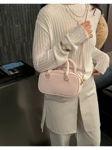 Detailed view of stylish pink bowling shoulder bag, trendy faux leather daily crossbody purse.