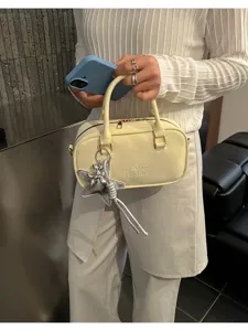 Detailed view of stylish women's bowling pillow handbag, trendy PU leather shoulder bag.