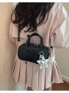 Black leather Boston handbag shoulder bag with silver star charm detail worn by model