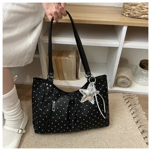 Detail view of black polka dot PU tote bag with cute star charm, large capacity commuter bag.