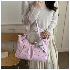 Pink polka dot PU leather tote bag detail, featuring shoulder strap and silver star charm.