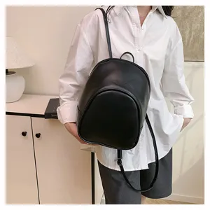 Closeup view of the black leather fashion backpack worn by a model in casual outfit.
