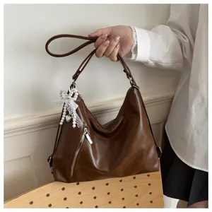 Sac a main slouchy en similicuir marron avec noeud perle et poche zippee pour les femmes chic.