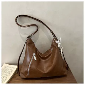 Vue détaillée du sac à épaule marron élégant en cuir avec fermeture éclair et perle.