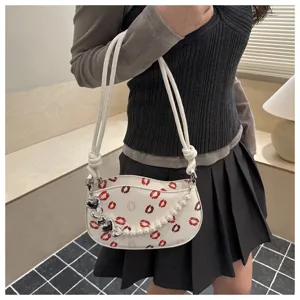 Sac bandoulière mini tendance pour femme avec imprimé lèvres, perle et design croissant chic.