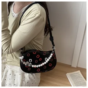 Petit sac porté épaule croissant noir avec imprimé lèvres, chaîne cœur et sangle perles.