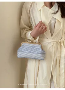 Sac bandoulière rétro avec fermoir baiser, rayures bleues et blanches et chaîne élégante.