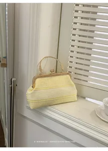 Détail de sac à main vichy jaune et blanc, pochette rétro avec fermoir métallique sur le rebord.