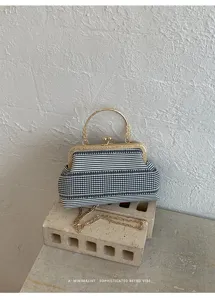 Sac à main élégant à rayures avec poignée en métal rétro et détail de chaîne chic.