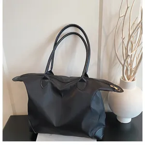 Large capacity black travel tote bag for women, lightweight overnight weekender bag.