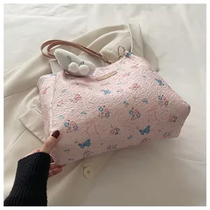 Nahaufnahme der rosa strukturierten Tragetasche mit Schmetterlingsmuster und Anhänger.