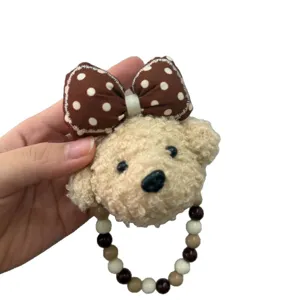 Porte-clés en peluche de chiot mignon avec nœud à pois marron et sangle de perles.