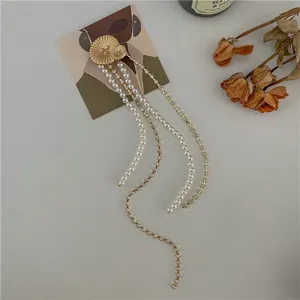 Spilla vintage con perle dorate e nappe, elegante design floreale per accessori moda.