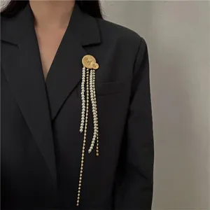 Elegante spilla in stile retrò con perle e nappe dorate impreziosita da luminosi strass.