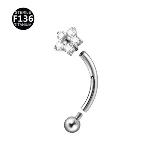 Dettaglio del piercing in titanio con top a fiore di cristallo scintillante e asta curva.