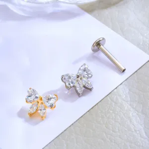 Dettaglio piercing labret fiocco in titanio e zirconi, pietre scintillanti e finitura lucida.