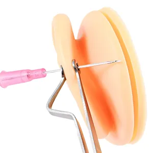 Professional body piercing needle set with stainless steel catheter and silicone practice pad tool.