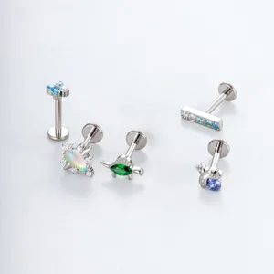 Titanium labret stud piercing jewelry detail showing various zircon floral and animal shapes.