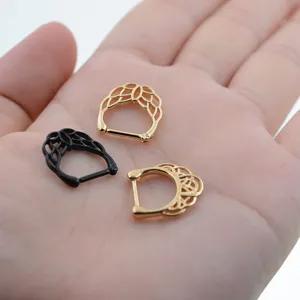 Gros plan detail de bijoux de piercing de corps en anneau segment filigrane dore et noir.