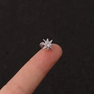 Nahaufnahme Detail von zarter Stern Knorpel Piercing Stecker am Finger mit funkelndem Zirkon.
